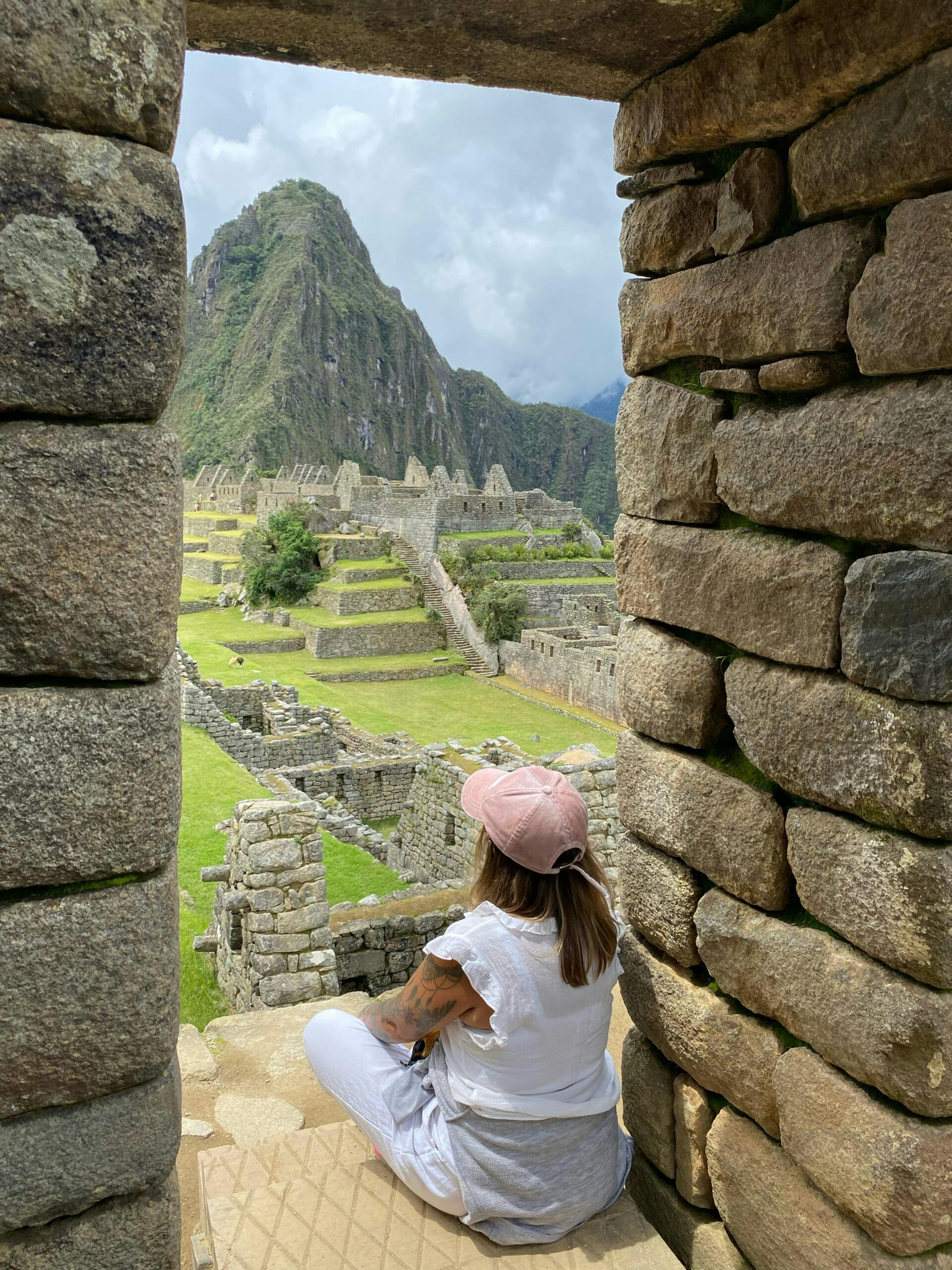 Traveler looking through an Inca stone window in Peru
